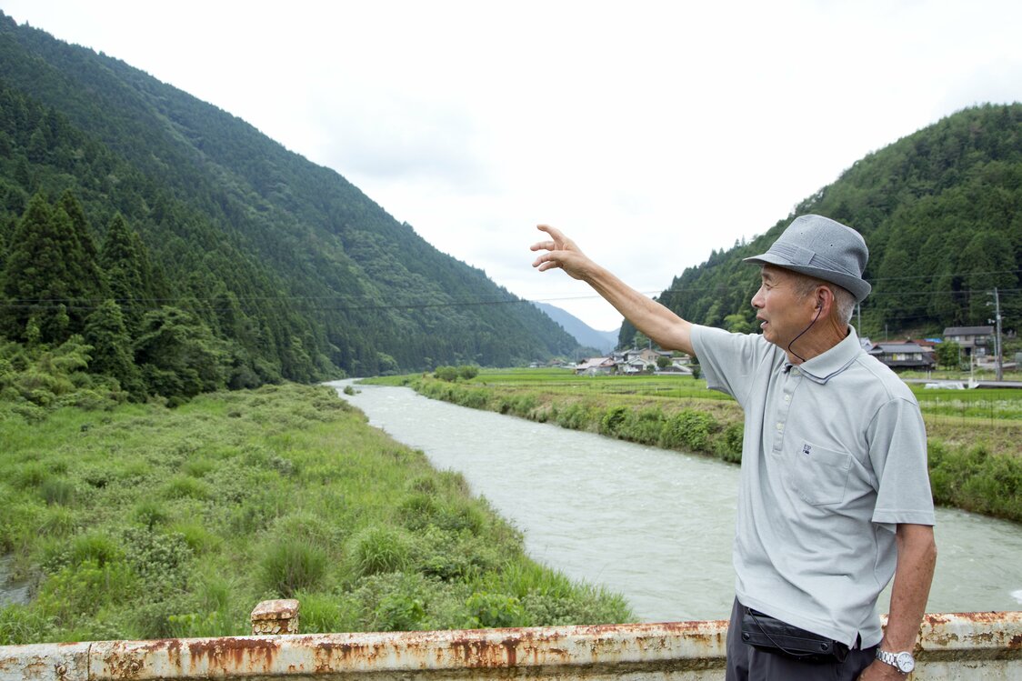 川の左側が大雨地域（援護対象）となる一方、本毛さんの自宅のある対岸は小雨地域とされた。（撮影・堂畝紘子）