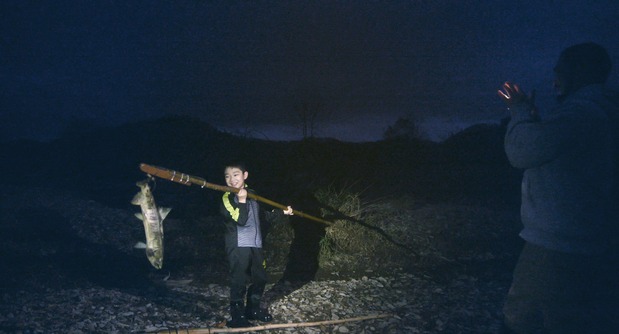 Motoki sostiene una presa con su marep. (© 2024 Takeshi Fukunaga/AINU PURI Production Committee)