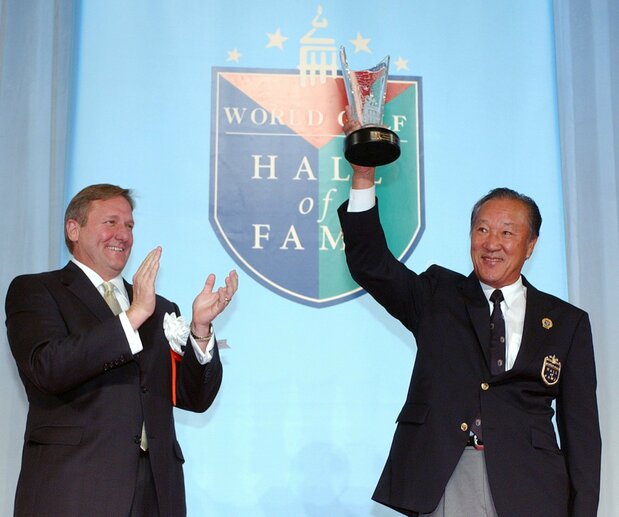 Aoki Isao (à droite) brandit un trophée commémoratif durant sa cérémonie d’intronisation au World Golf Hall of Fame, célébrée à Tokyo le 9 décembre 2004. (Jiji)