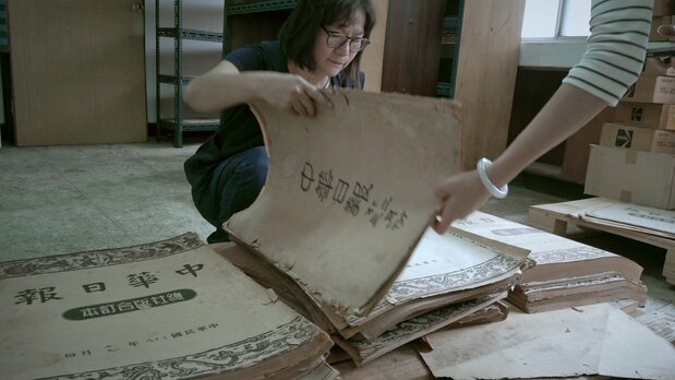 A journalist looks through back issues of the China Daily News, the only newspaper to keep publishing without a break during shutdowns and news blackouts in the turmoil that followed February 28, 1947. (© Mirror Film Production)