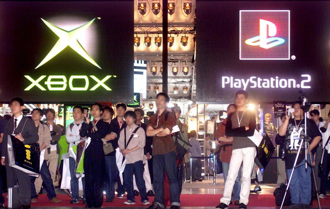 Посетители осенней TGS 2001 года смотрят демонстрацию новых игр для Xbox и PS2 (© Reuters)