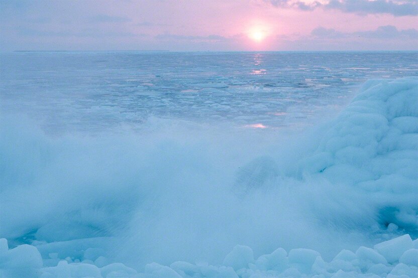 The sun rising above drift ice that has moved around the Nemuro Peninsula to head south in the Pacific Ocean. (© Mizukoshi Takeshi)