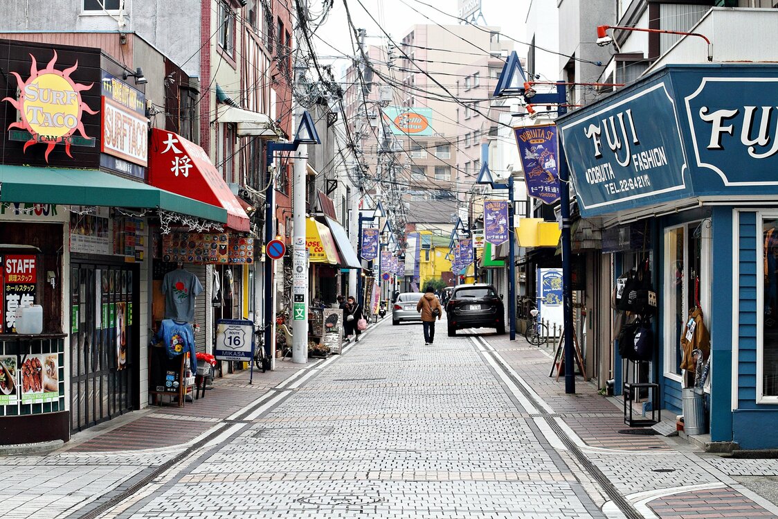 ドブ板通り商店街には、英語表記の看板を掲げた飲食店や土産物屋が立ち並ぶ