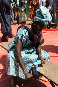 A woman demonstrates a corn husking machine introduced by SAA.