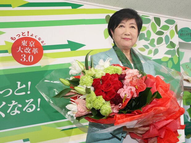 都知事選3選を決め、花束を手にする小池百合子氏(時事)