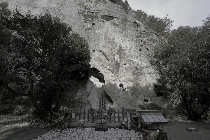 El área de rezo frente a la pared de roca, con su suelo cubierto de piedras blancas, tiene aspecto de antiguo lugar ritual. (Fotografía de Ōsaka Hiroshi)