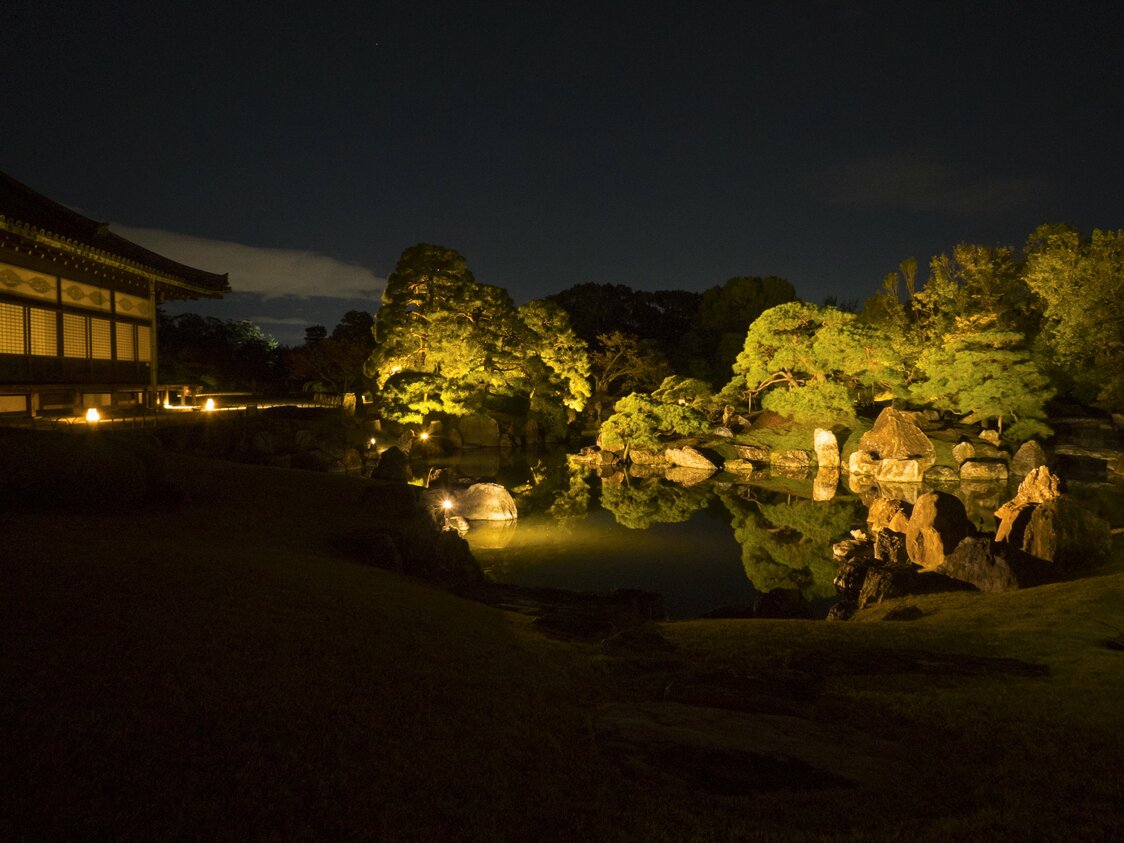 Ninomaru Gardens by night, reflected in the mirrorlike surface of the lit-up pond. At left is the great hall of Ninomaru Palace, where the restoration of imperial power took place.