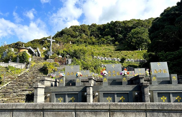 The Nomichi Christian Graveyard climbs a steep hillside in terraces and was apparently designed by Father de Rotz. For the 46 years until his death in 1914, the father stayed here without once returning to his home of France. Now, his remains rest here eternally. It is around 10 minutes’ walk from Shitsu bus stop. (© Amano Hisaki)