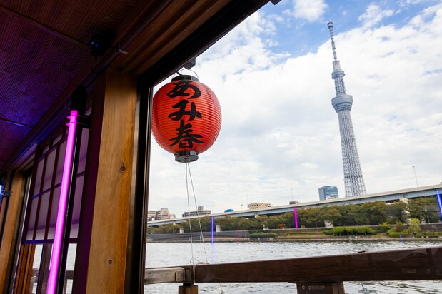 屋形船の赤ちょうちん越しに、東京スカイツリーを見上げる