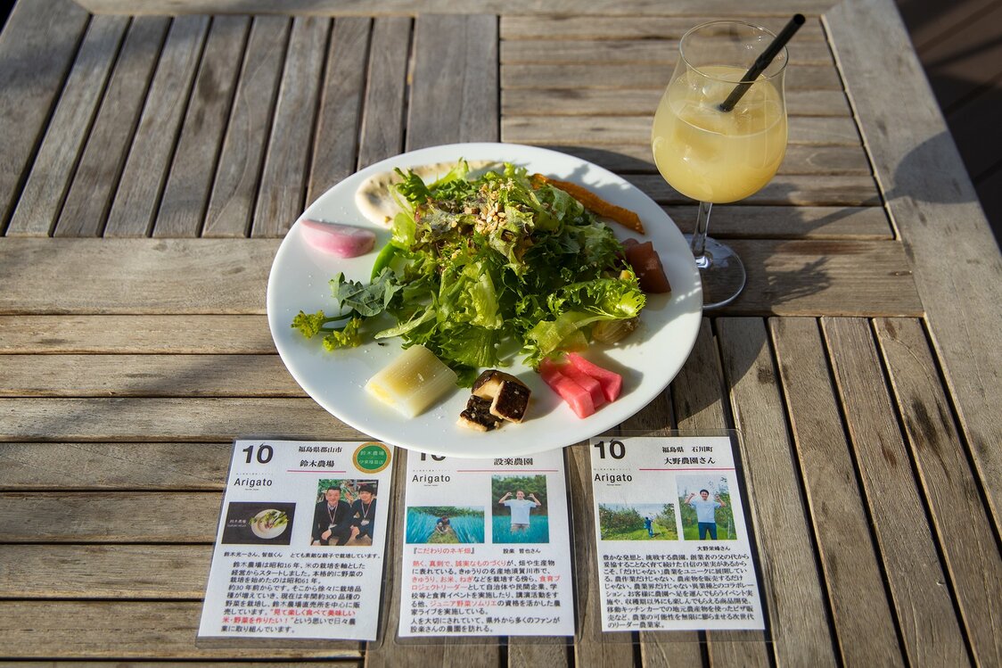 An Arigatō salad, accompanied by photo cards telling the stories behind the ingredients.