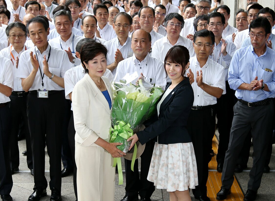 2016年7月、都知事選当選後、初登庁し、花束を受け取る小池新都知事（時事）