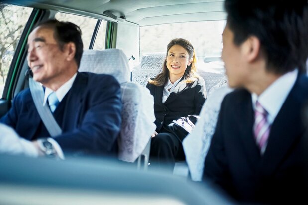 When boarding a taxi with just one other person, it is considerate to ride in the front passenger seat to give the driver directions or pay the fare smoothly. (© Pixta)