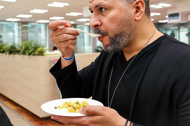 An Arabic editor at Nippon.com tucks into a plate of biryani. (© Nippon.com)
