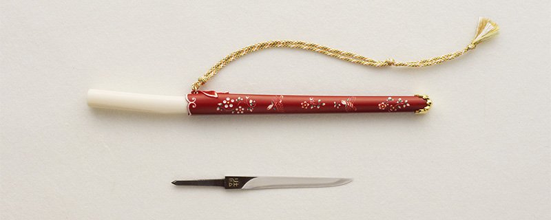 Tōsu con vaina de marfil teñida y tallada con delicados motivos.