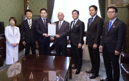 Yuichiro Tamaki (third from right), leader of the Democratic Party for the People, and other party officials submit to the House of Representatives a bill serving as a counterproposal to the government's legislation on a consumption tax cut, at the Diet building in Tokyo on Tuesday.