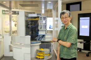 Hayashi beside a model of the Subaru Telescope on exhibit at the National Astronomical Observatory’s headquarters in Mitaka, Tokyo. (© Nippon.com)