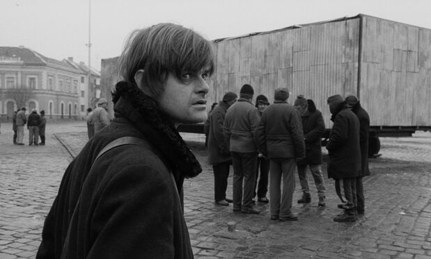 映画『ヴェルクマイスター・ハーモニー』。ヤーノシュ(ラルス・ルドルフ)は「世界一巨大なクジラ」を見に、人々が群がる広場を訪れる © Göess Film, Von Vietinghoff Filmproduktion, 13 Production