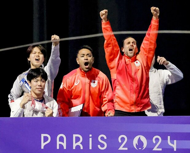 Erwann Le Péchoux (right) raises his arms in celebration at Japan’s dramatic win in the final of the men’s team foil on August 5, 2024, in Paris, France. (© Kyōdō)