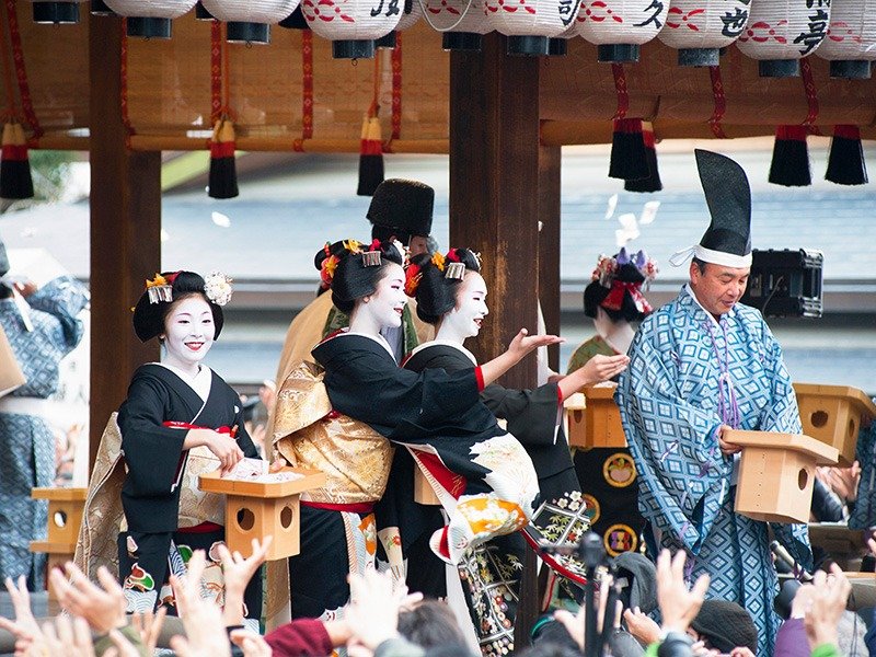 Les visiteurs cherchent à attraper les haricots de soja que lancent les maiko, les apprenties geisha.