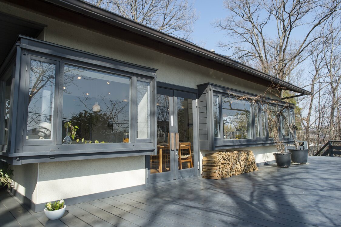 The large windows of Nazuna mirror the surrounding trees and landscape.
