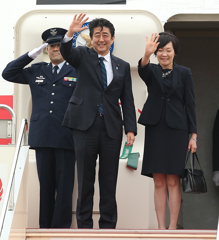 El primer ministro Abe Shinzō (centro) y la primera dama Akie (derecha) se preparan para iniciar su tour por Europa. (© Jiji Press)