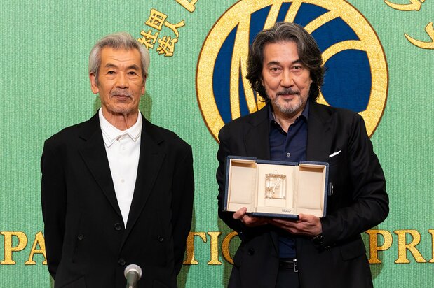 手拿獎盃在日本記者俱樂部見面會上登臺的役所廣司(右)和同劇組演員田中泯
