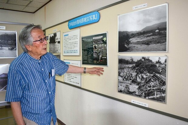 柏原公民館に展示している水害の写真などについて説明する中尾祐蔵さん