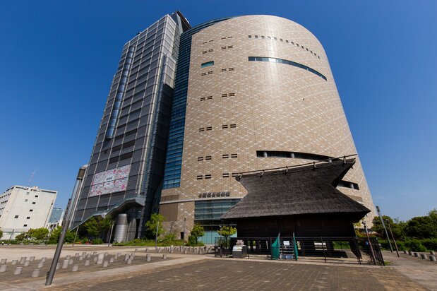 NHK大阪放送局(左)と連結している大阪歴史博物館。手前のかやぶき屋根は「法円坂遺跡復元倉庫」