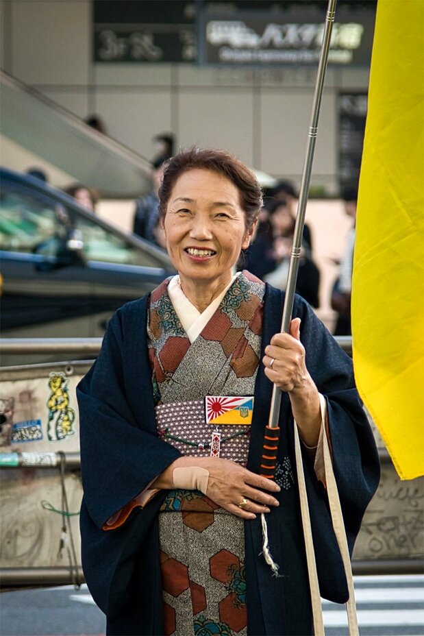 A woman carries a Ukrainian flag in support of the country at a well-attended November 2024 event in Shinjuku, Tokyo. (© Yuliana Romaniv)