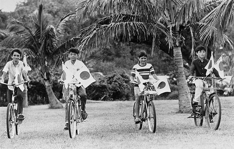 小笠原が返還された1968年6月26日、日の丸の小旗を自転車に付けた父島の子供たち（時事）