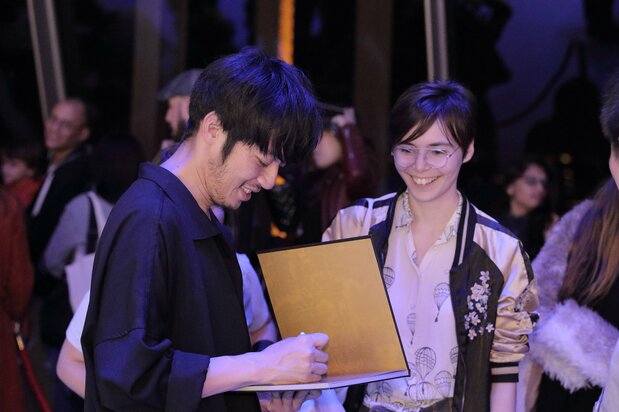 「光る絵本展」の会場で作者にしのあきひろからサインをもらい、目を輝かせるファン