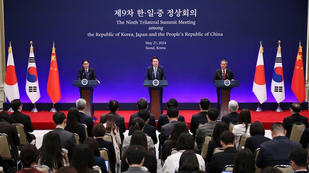 El presidente Yoon (en el centro) habla durante una rueda de prensa conjunta con el primer ministro Kishida (a la izquierda) y el primer ministro Li en Seúl el 27 de mayo de 2024. (© Reuters)
