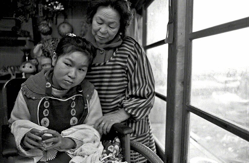 Tanaka Jitsuko à l’âge de 18 ans, en compagnie de sa mère. Elle est en train de regarder la mer à travers les fenêtres de la maison familiale. (Photo prise en 1971)