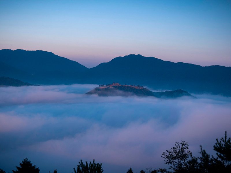 À l’aube, le château de Takeda flotte au-dessus des nuages.