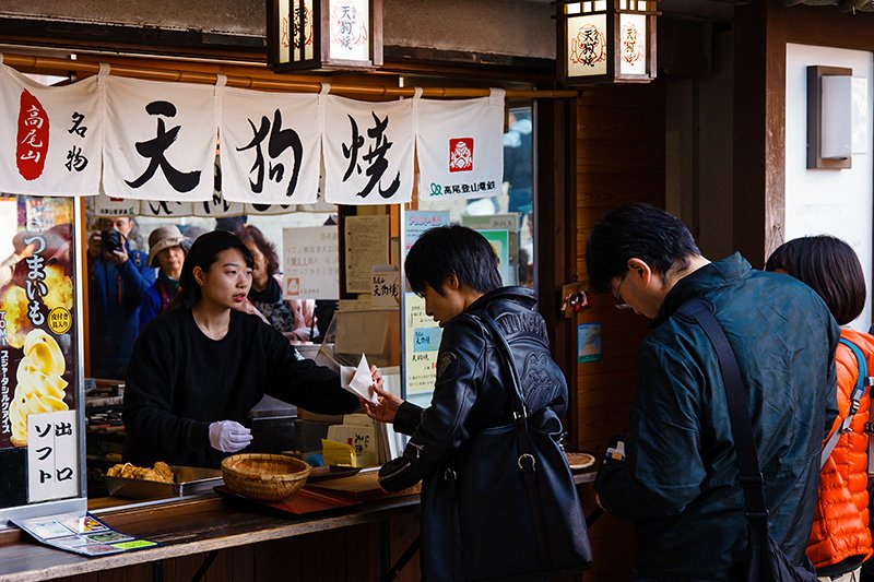 高尾山站前饭馆和土特产店鳞次栉比，其中最受欢迎的是“香住卖店”的“天狗烧”，2007年至今累计销量已突破300万个