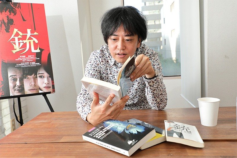 Nakamura Fuminori en train de lire les premières lignes de Revolver (Éditions Picquier), la traduction française par Myriam Dartois-Ako de son premier roman.