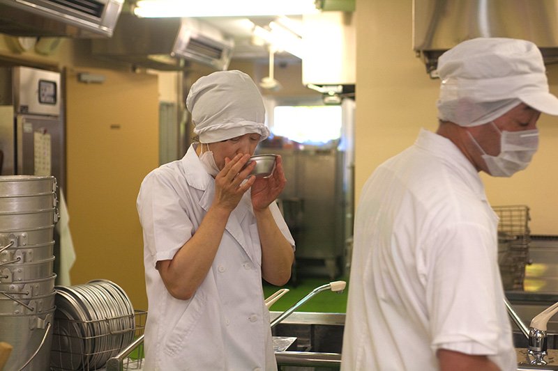 完成前に「すましじる」の味見をする川口芳枝栄養士。