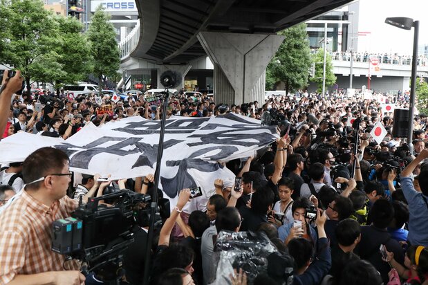 在安倍晋三首相为东京都议会选举助选发表演说期间，大批民众高举“安倍下台”的标语横幅抗议示威（2017年7月1日，东京都千代田区JR秋叶原站前，时事社）