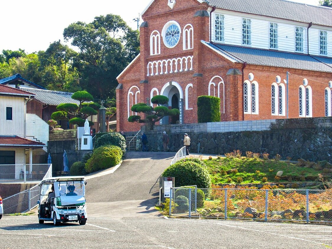 国重要文化財・黒島天主堂の前を走る4人乗りのグリスロ。公共交通機関のない島の新たな足として、観光ばかりでなく将来的には地域のコミュニティモビリティとしての活用も目指すという　　黒島観光協会提供