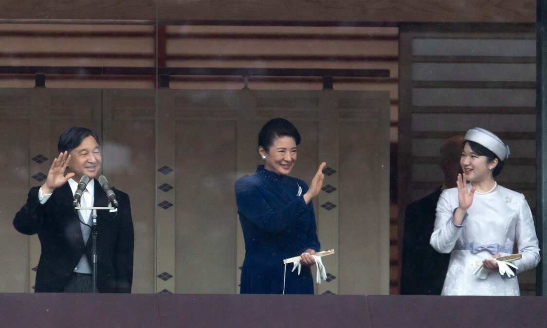 Emperor Naruhito (left), Empress Masako (center), and Princess Aiko wave to well-wishers at the Imperial Palace. (© Reuters)