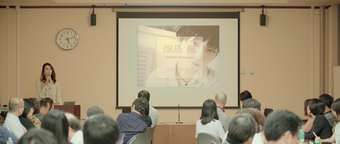 ساري كائيدي في مؤتمر حول المتحولين جنسياً في إحدى الجامعات. من فيلم موسوكو نو ماما دي جوشي ني نارو أو حرفيًا ”أن تظل ابنًا دائمًا في نظرهم حتى وإن صرت امرأة“، (الترجمة الإنكليزية أنت من يقرر) 2021.