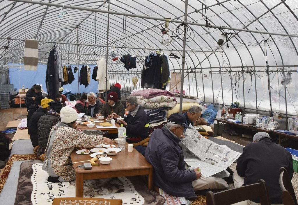 能登半島地震で、ビニールハウスの中で避難する人たち＝2024年1月9日、石川県輪島市（共同）