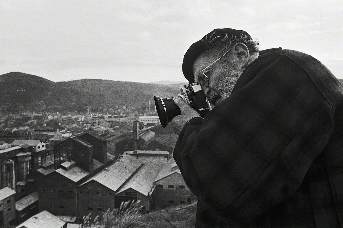William Eugene Smith en train de photographier l’usine pétrochimique Chisso, du haut des collines qui dominent la baie de Minamata. (Photo prise en 1971)