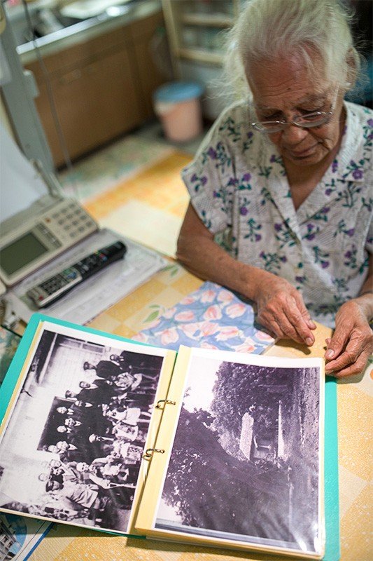 古い写真を見ながら、戦前・戦時中の島の暮らしを語る京子さん
