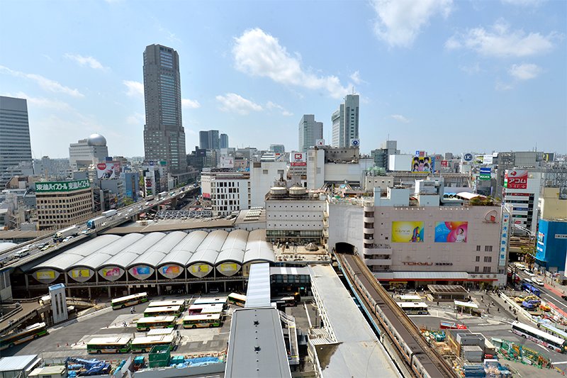 东横线涩谷站于2013年移至地下。这是此前位于地上的旧站台（中左侧，1964年完工）和东急百货东横店的东楼（中右，1934年完工）（摄于2012年4月，时事通信photo）