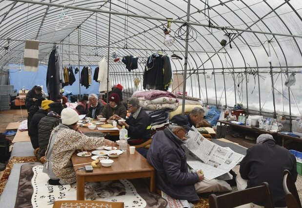 能登半島地震で、ビニールハウスの中で避難する人たち＝2025年1月9日、石川県輪島市（共同）
