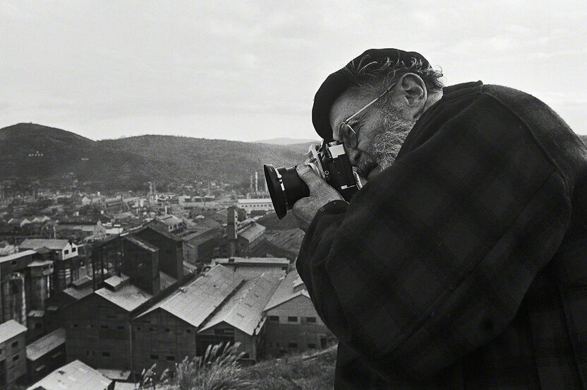 William Eugene Smith en train de photographier l’usine pétrochimique Chisso, du haut des collines qui dominent la baie de Minamata. (Photo prise en 1971)