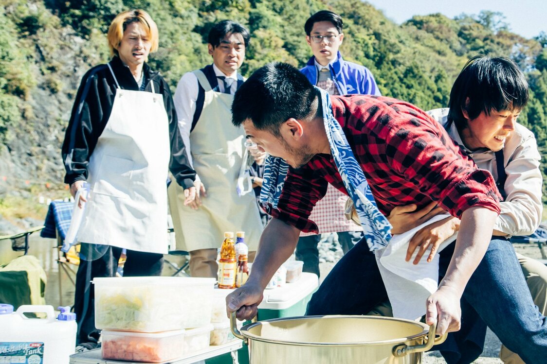 「モモちゃんの幸せを祈る会」のメンバー［左から：タケ（三宅健）、山城（山本浩司）、ケン（竹原ピストル）、平畑（好井まさお）］が晋作にカラみ、芋煮会はカオスに　©楡周平／講談社　©2024「サンセット・サンライズ」製作委員会