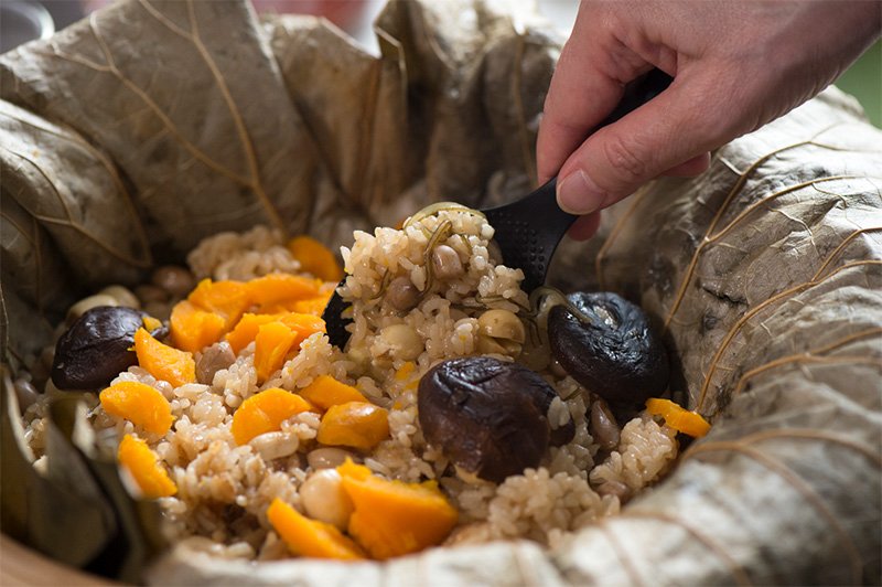 「荷葉香飯」是用大片蓮葉包裹糯米、未煮的花生米、蓮子、香菇、紅蘿蔔，蒸煮而成的料理。