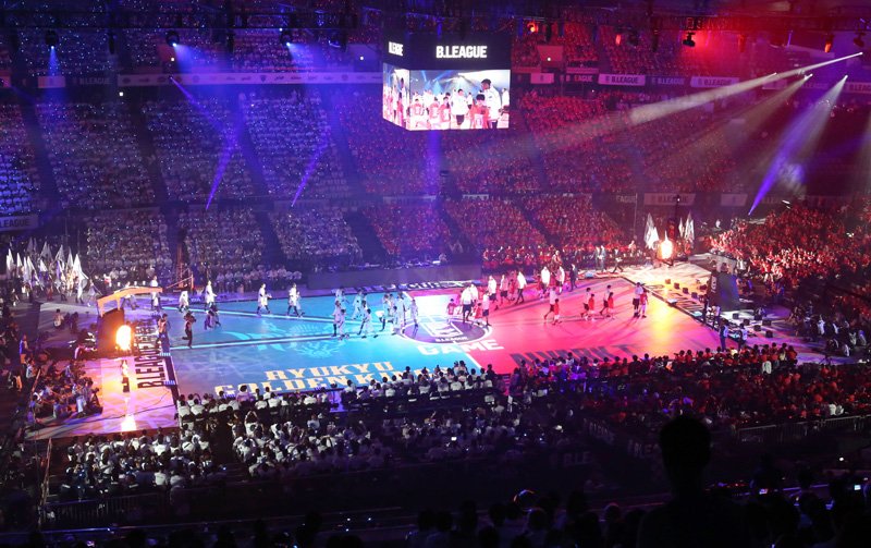 Players from Alvark Tokyo and Ryūkyū Golden Kings enter the LED-enhanced court for a ceremony held before the opening match of the B. League at the Yoyogi National Gymnasium in Tokyo on September 22, 2016. (© Jiji)